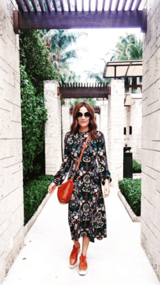 Los zapatos y la bolsa hacen un contraste perfecto con este vestido floreado.