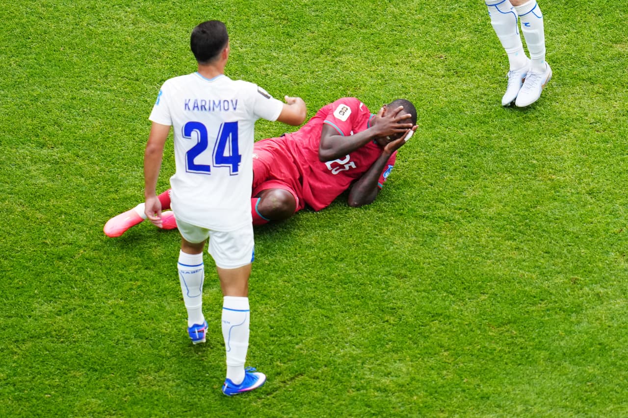 Nuno Mendes (25), de Portugal, reacciona tras chocar con Behruzjon Karimov (24), de Uzbekistán, durante el partido de fútbol del Grupo K de la Copa Mundial