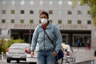 Una mujer lleva puesta una máscara quirúrgica luego de abandonar el hospital Fundación de Alcorcón, donde una enfermera dio positivo por el virus Ebola después de tratar a dos pacientes con el mortal virus.
