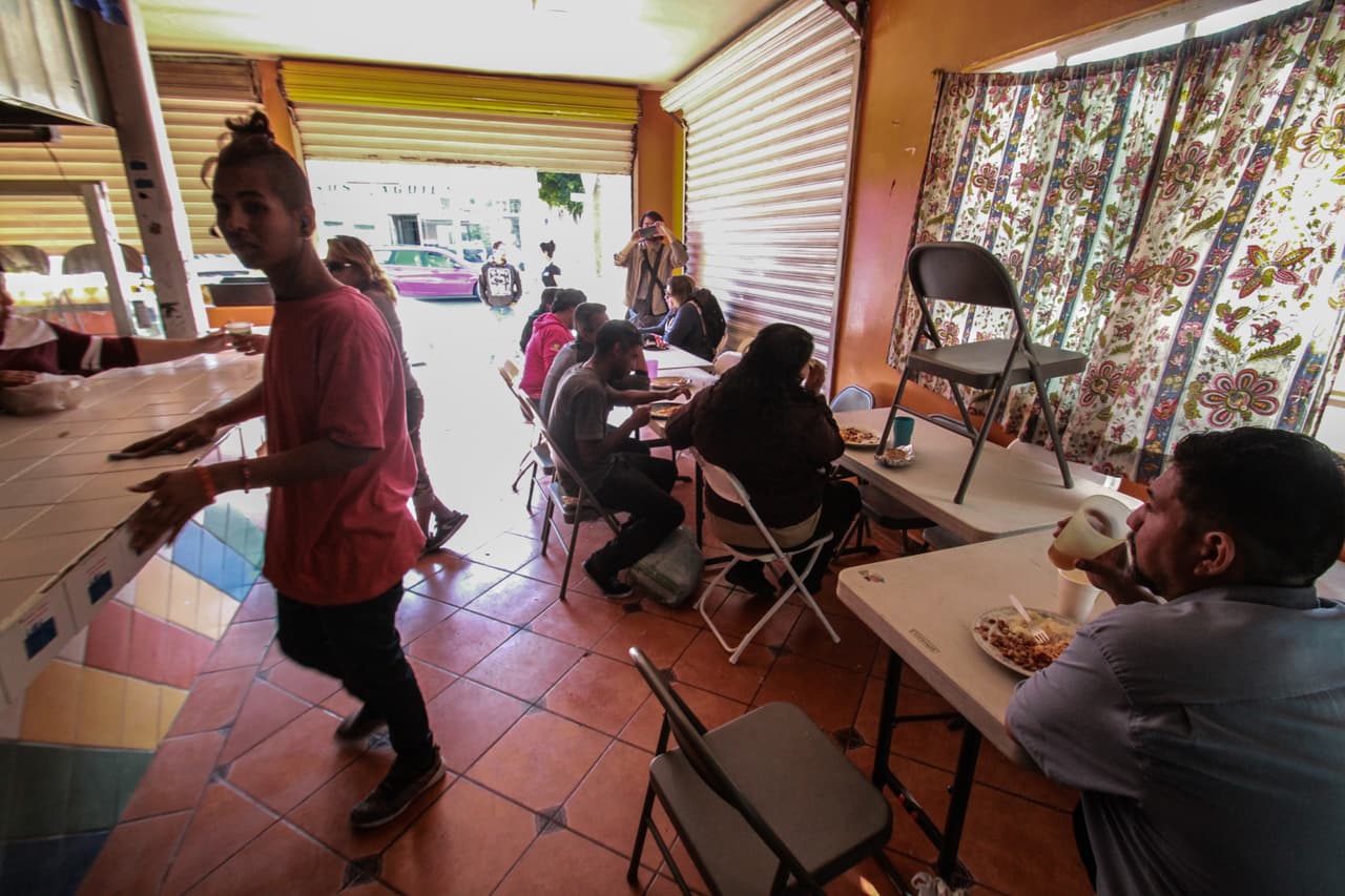 Migrantes centroamericanos de diversos países preparan comida para servirle a la comunidad que se acerca al comedor.