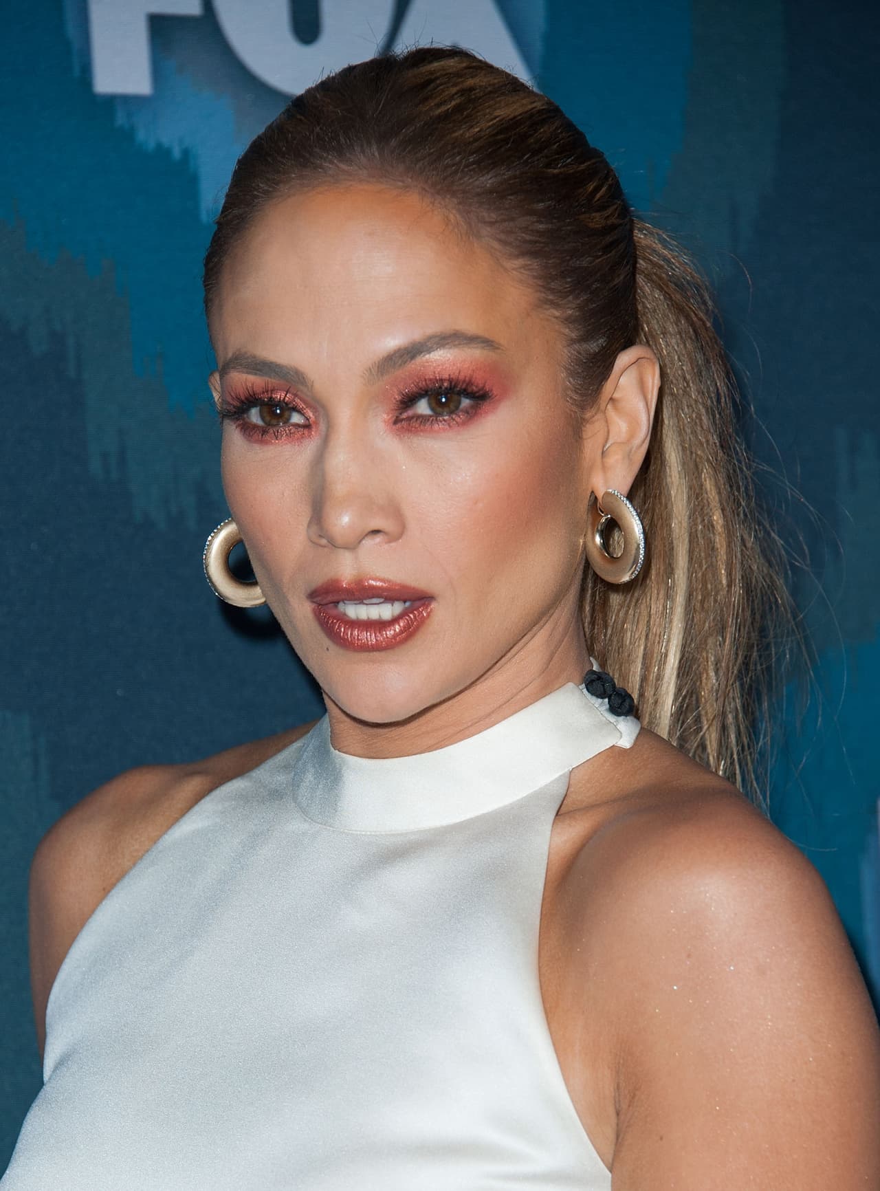 La cantante Jennifer Lopez también prefiere lucir una coleta con el cabello relamido, resalta sus facciones y su maquillaje se convierte en el protagonista.