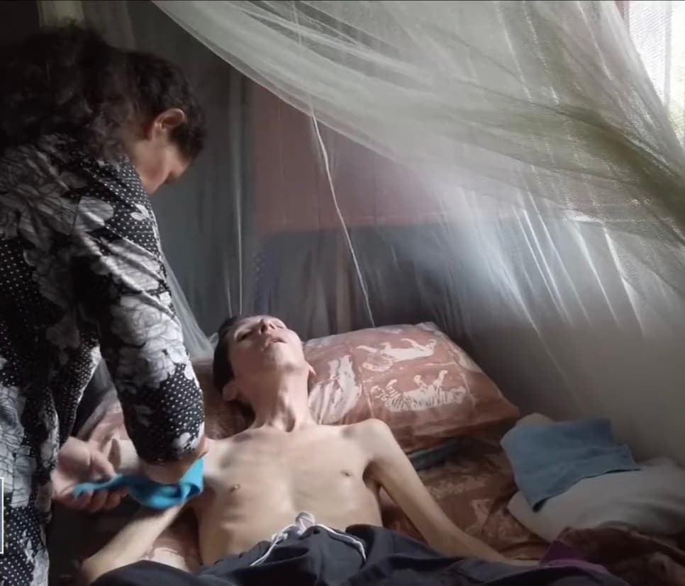 Con 36 años cumplidos, Misael tiene que ser atendido recurrentemente mientras permanece postrado en una cama dentro de una habitación estrecha, siempre al cuidado de sus padres, quienes se encargan de asearlo