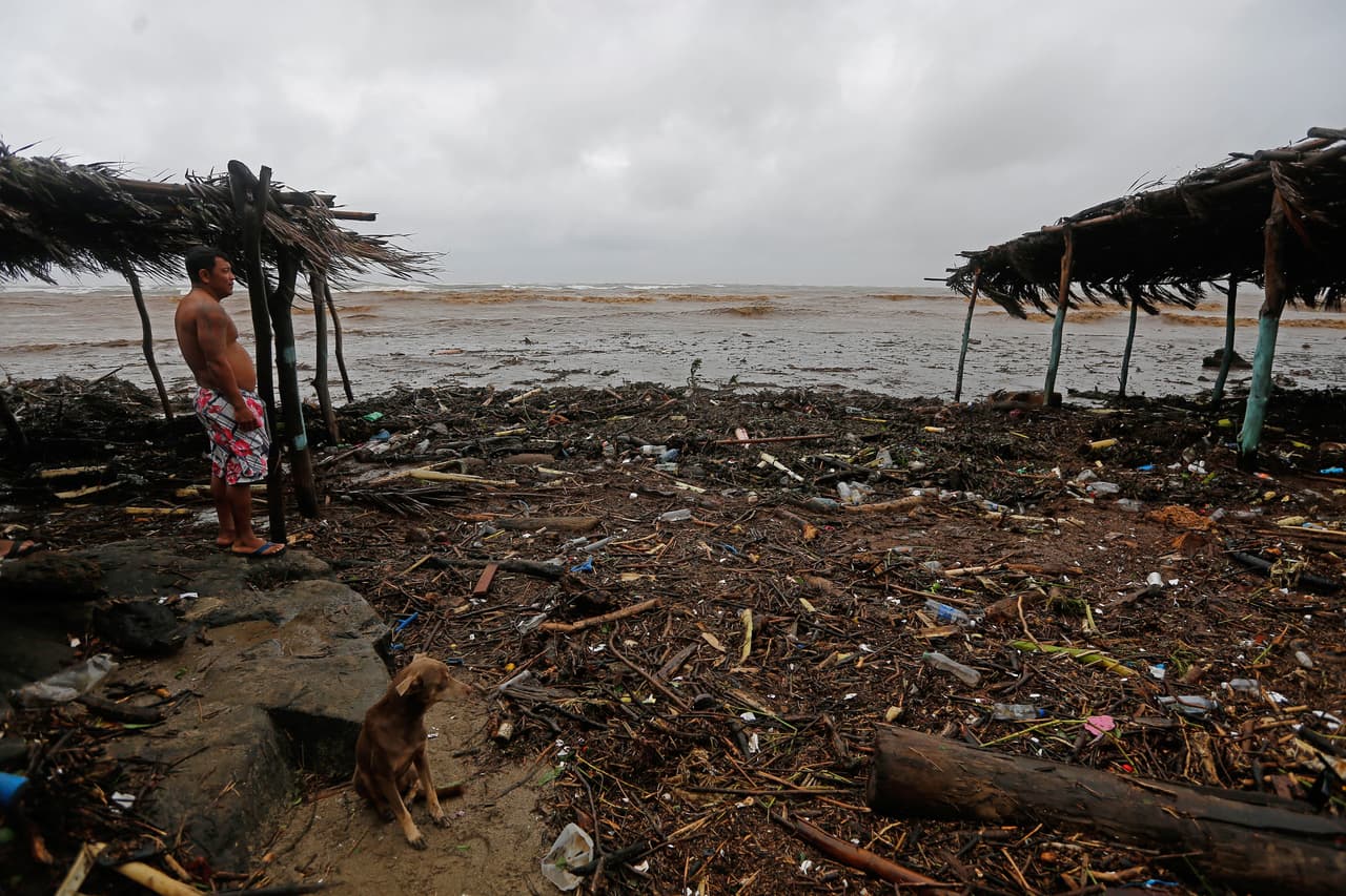 COSTA RICA- Un hombre y un perro caminan entre los destrozos después de que la tormenta tropical Nate golpeara en San José.
