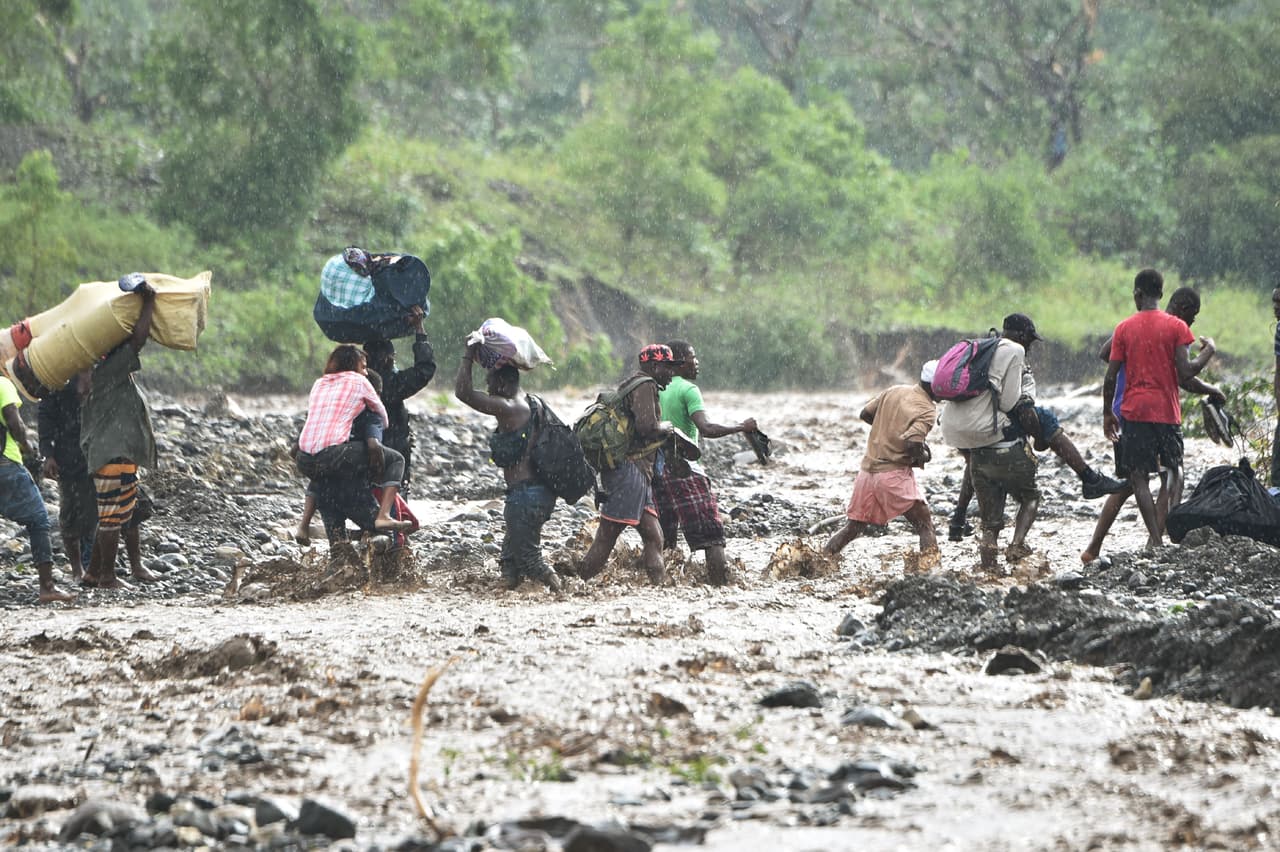 Un puente colapsó por las lluvias en el río La Digue, al suroeste de Port-au-Prince, lo que obliga a las personas cruzar a pie las aguas desbordadas.