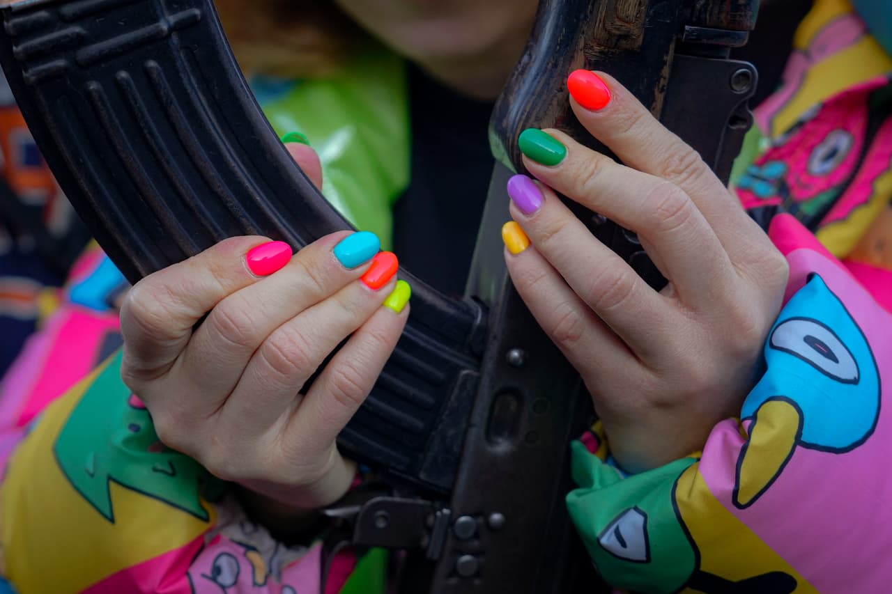Unas manos con las uñas pintadas de rosa, azul y púrpura pastel agarran el cañón de una pistola. Es durante un entrenamiento organizado por la Unidad de Fuerzas Especiales Azov, de la Guardia Nacional de Ucrania, en la región de Donetsk.