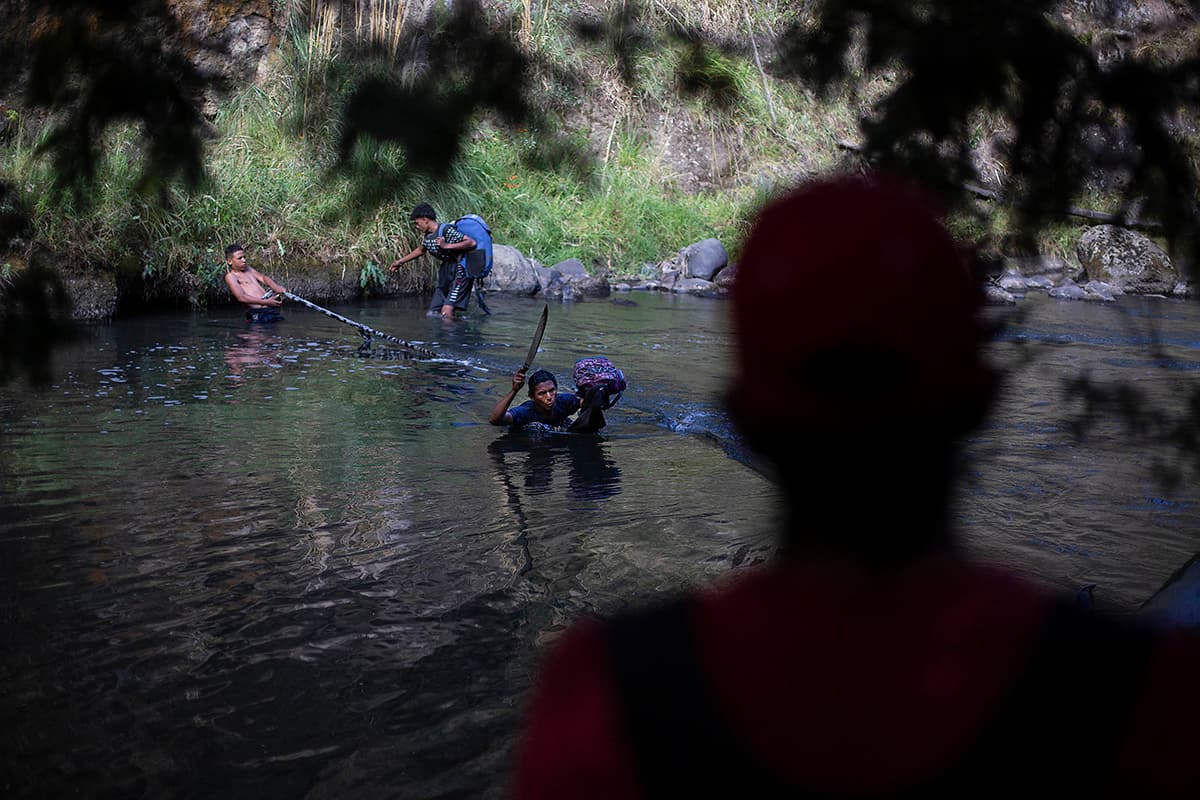 Los migrantes, deseosos de seguir camino, se meten en las frías aguas apenas quitándose los zapatos. Del otro lado les espera una montaña que les lleva a poblaciones rurales de Carchi, la provincia fronteriza. 
<br>