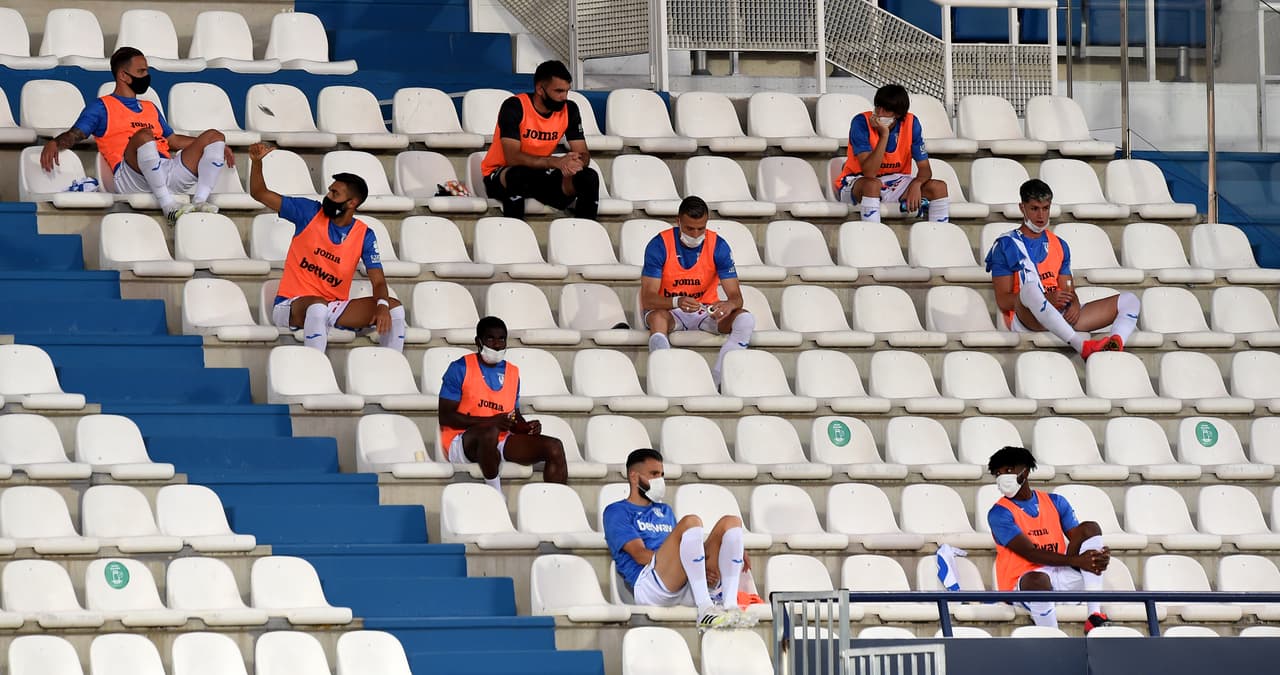 Los sustitutos del Leganés permanecen con distancia entre ellos en las butacas del estadio.