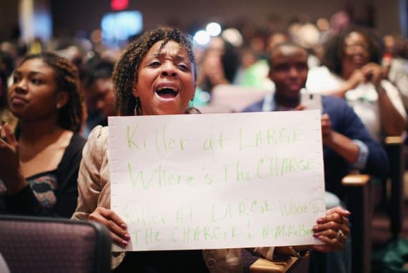 Una mujer sostiene un cartel de protesta durante la ceremonia.