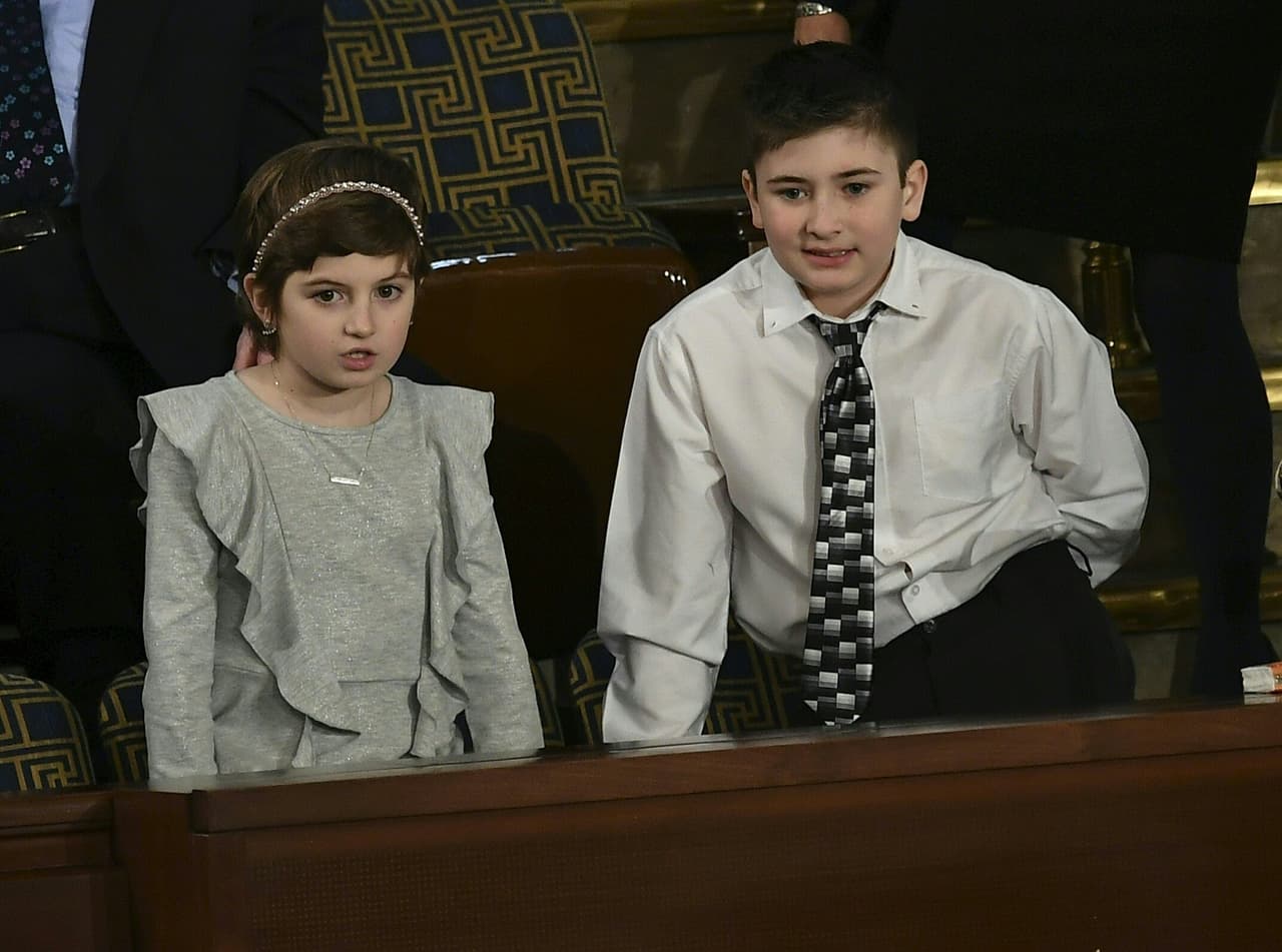 Los invitados especiales del presidente, Grace Eline y Joshua Trump toman sus asientos.
