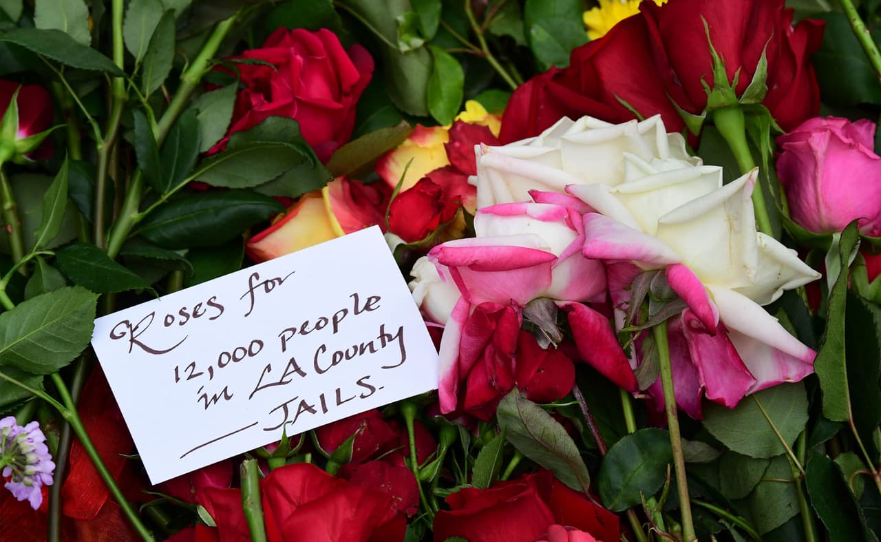 "Rosas para 12,000 personas en las cárceles del condado de Los Ángeles", se lee en una tarjeta de un altar improvisado en el ayuntamiento de la ciudad, pidiendo justicia por casos presuntamente irregulares, que en su mayoría relacionados con personas de color.
<br>
<br>