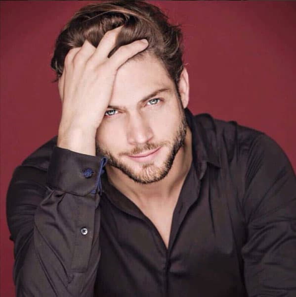 Sus ojos azules se iluminan con la luz de los reflectores, sabe cómo coquetear con la cámara.