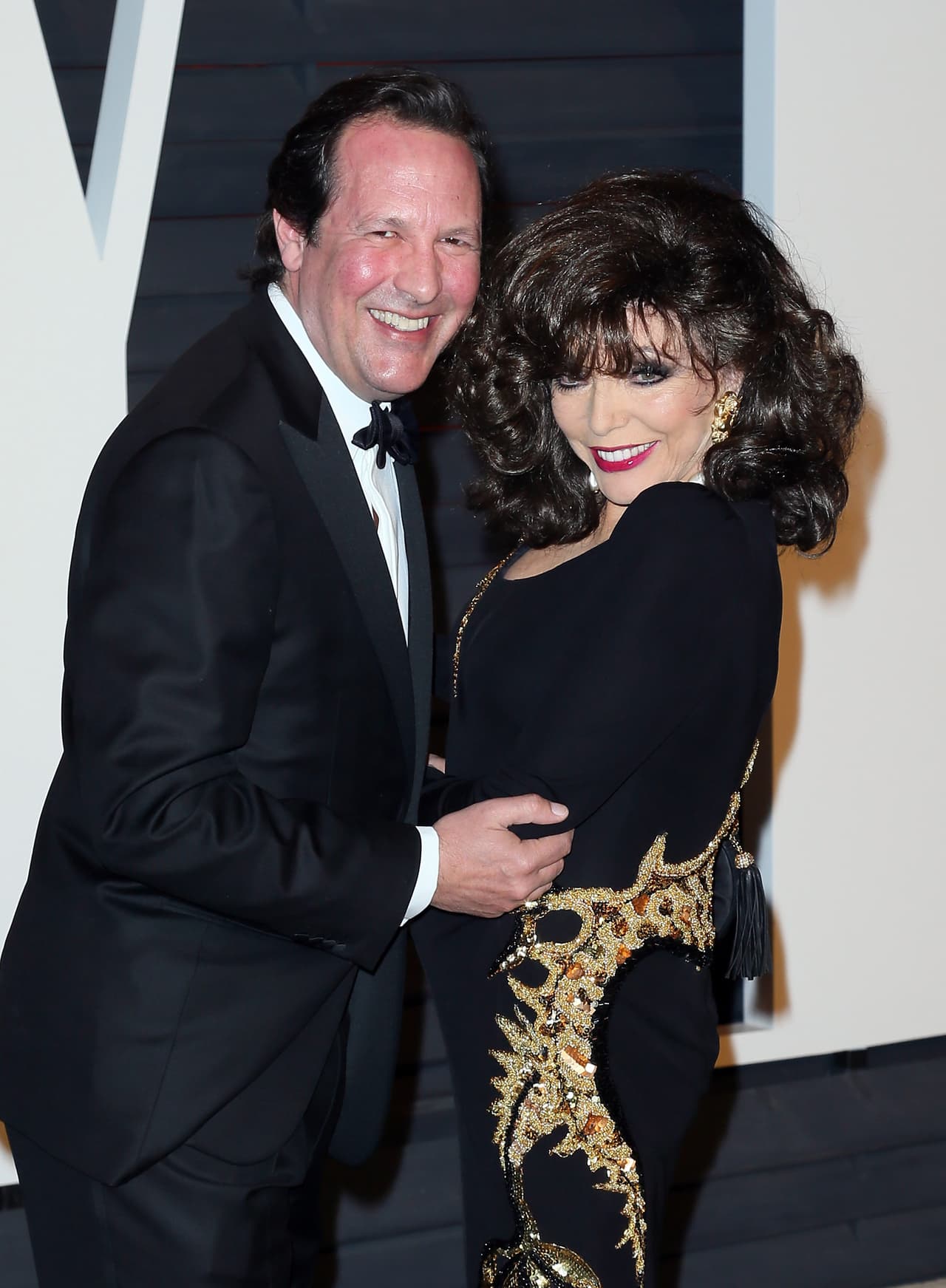 Actriz Joan Collins (D) y su esposo, el actor Percy Gibson en la Vanity Fair Oscar Party