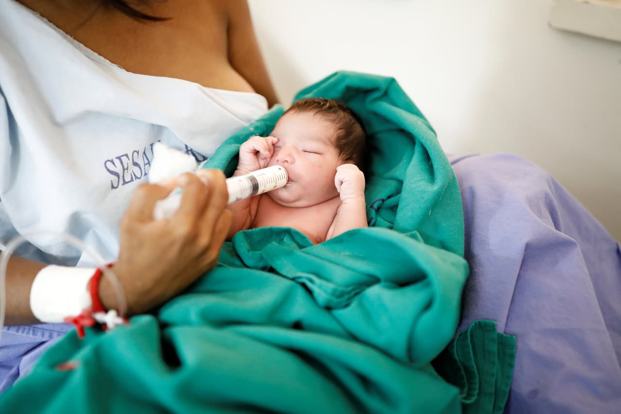 Maria Teresa Lopez, 20, a Warao Indian from Delta Amacuro state, uses a syringe to feed her one-day-old baby Fabiola, at a maternity hospital in Boa Vista, Roraima state, Brazil August 21, 2018. REUTERS/Nacho Doce