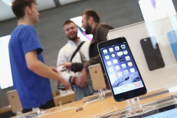 Los compradores platican con un asistente de ventas mientras el nuevo iPhone 6 se muestra en exhibición en la tienda de Apple de Berlín.