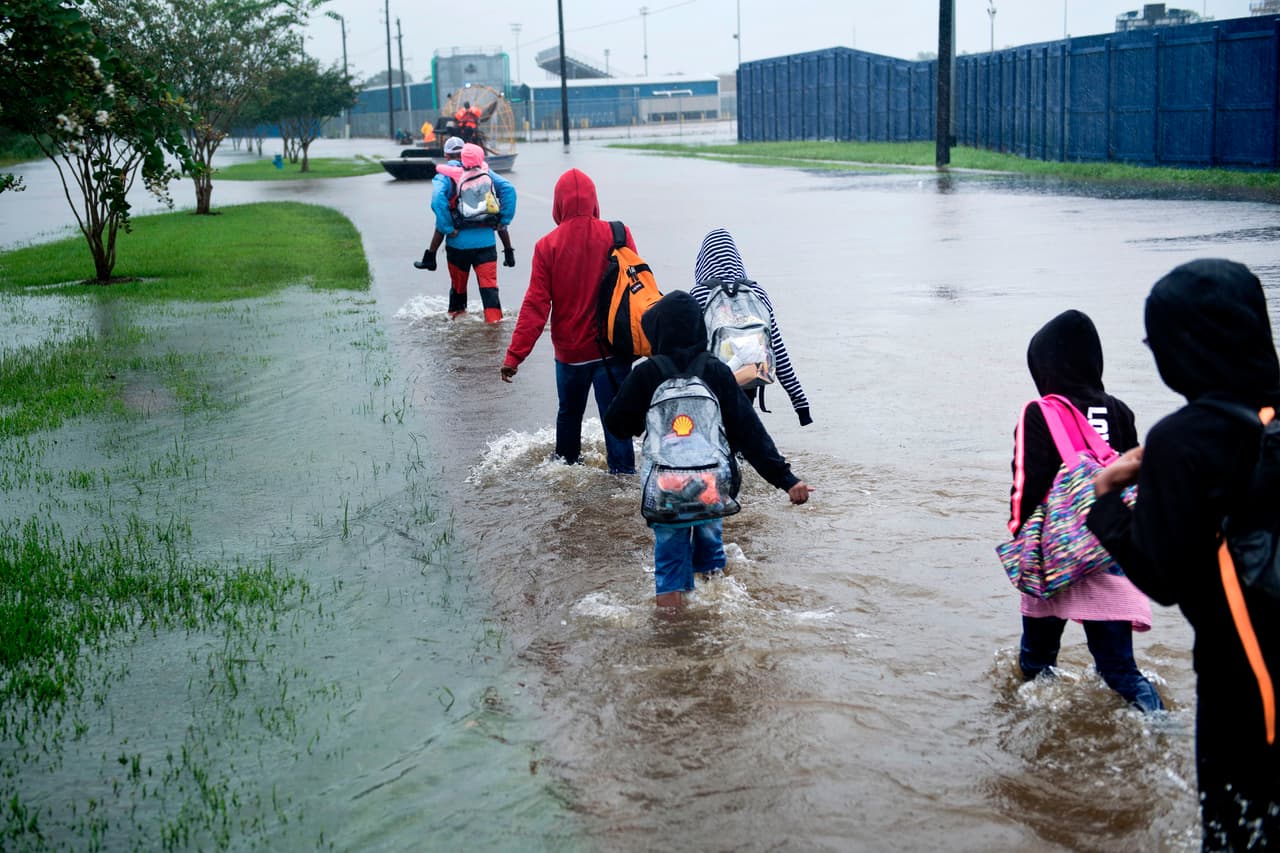 Una familia afectada por las inundaciones intenta ponerse a salvo en el condado Harris, en Houston.