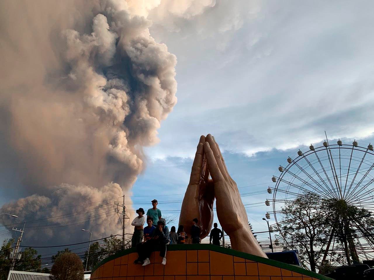 Desde Tagaytay, al sur de Manila, la gente observa la inmensa columna de humo que sale del volcán Taal. Miles de personas que viven en la zona fueron evacuadas de sus viviendas.