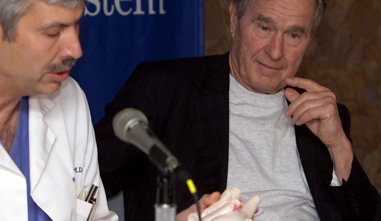 En esta imagen de febrero del 2000, el doctor Mark Hausknecht habla sobre el estado de salud del expresidente George W. Bush mientras éste lo escucha, durante una rueda de prensa en el Hospital Metodista de Houston.