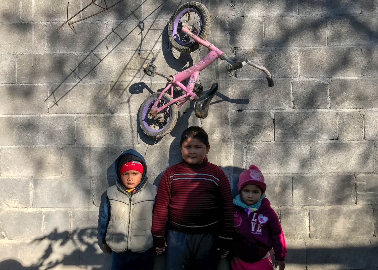 Los hijos de Carlos: Diego, Carlos Gregorio y América, recargados en una de las paredes de su casa.