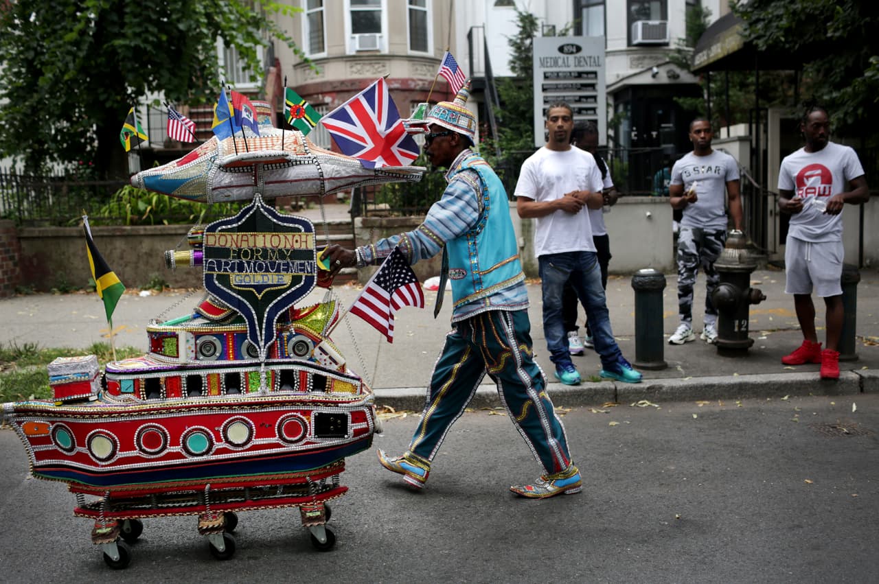 El artista Norman "Goldie" Harrison empuja a un orador que convirtió en un barco deslumbrante al desfile anual del Día de las Antillas.