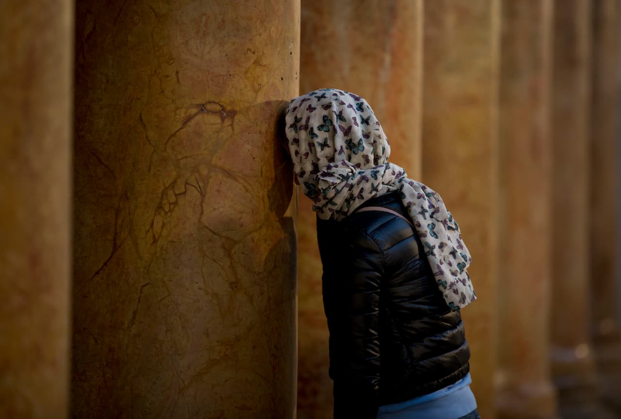 Wadie Abu Nasar, portavoz de las Iglesias de Tierra Santa, dijo que la Navidad debe seguir siendo un tiempo de esperanza. "La Tierra Santa no es solo el lugar de nacimiento y crucifixión (de Jesús), también es el lugar de la resurrección". Un creyente reza en una de las columnas del sitio sagrado cristiano.