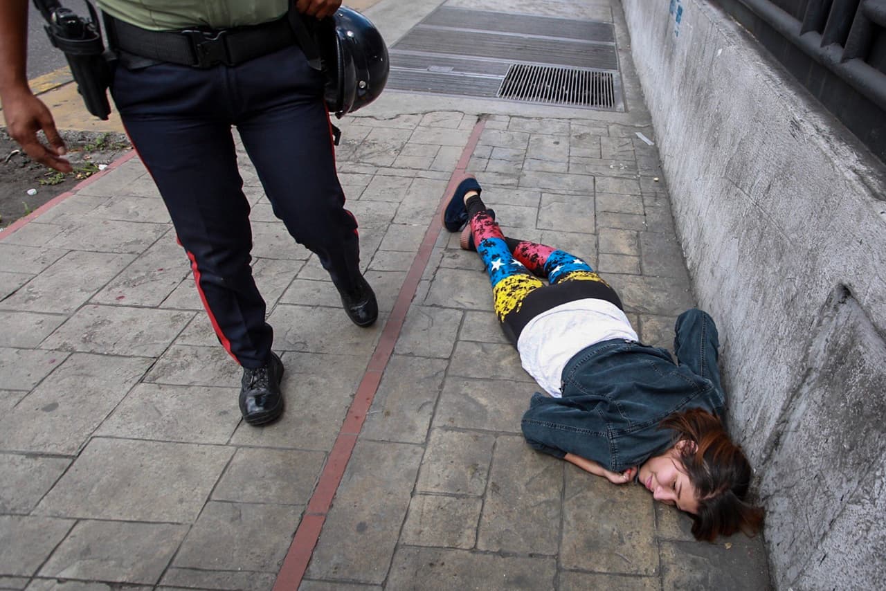 Una mujer yace herida en el suelo luego de que un grupo de hombres armados dispararan a la multitud mientras se celebraba la consulta opositora contra el proceso constituyente activado por el gobierno de Maduro. (EFE / Nathalie Sayago)