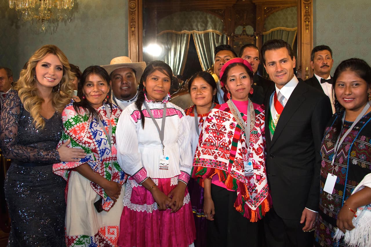 Rivera y Peña Nieto posaron con representantes de comunidades indígenas que fueron casualmente invitados al balcón con ellos a presenciar la ceremonia.