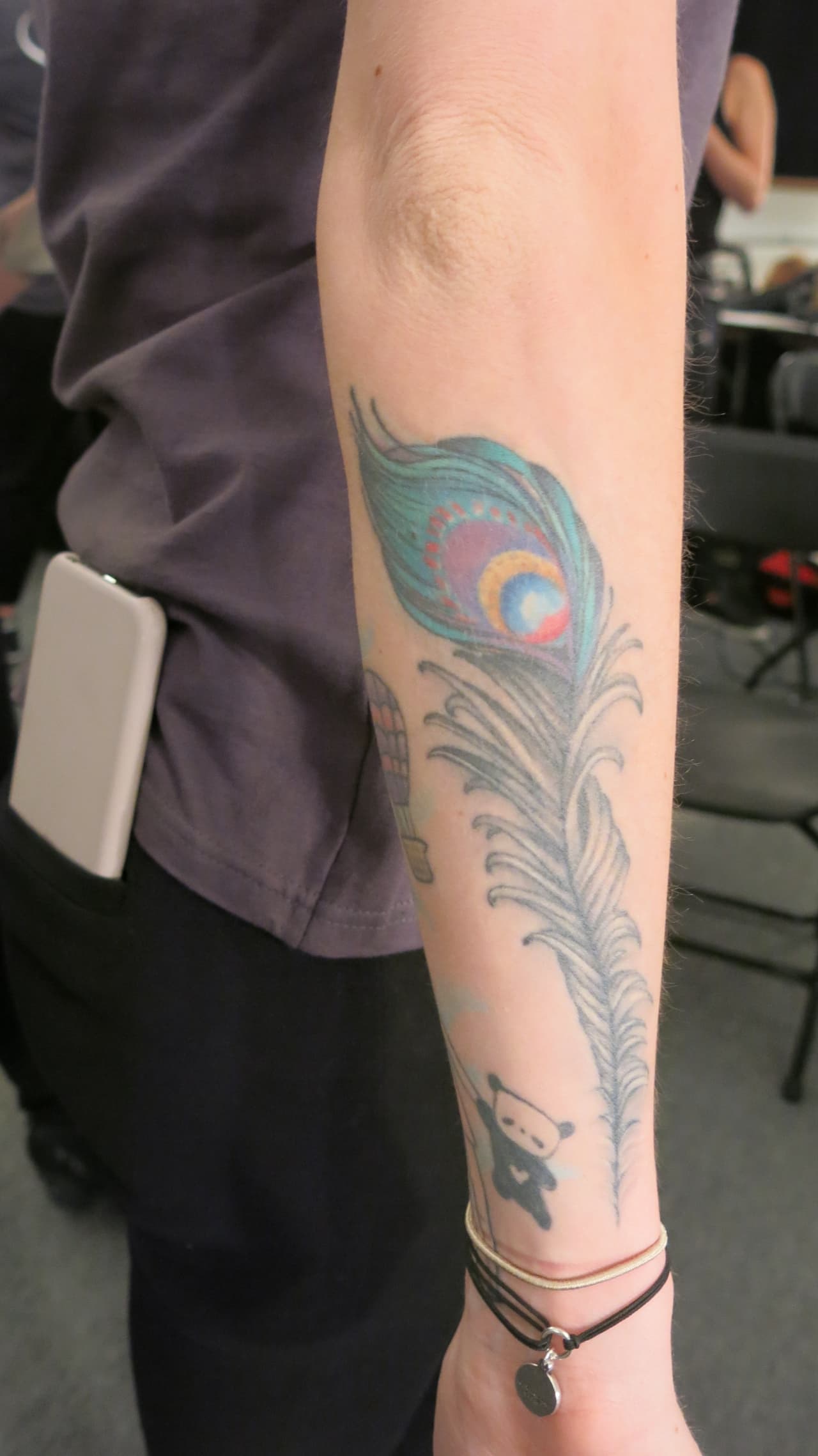 Los delicados y femeninos trazos de la pluma de avestruz decora el brazo de esta estilista.