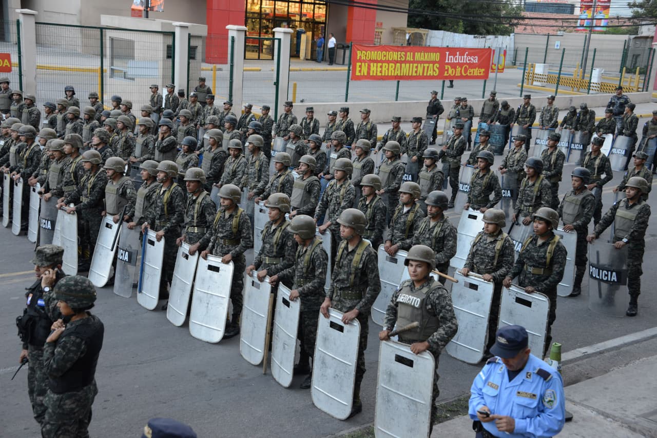 Policías y militares permanecen vigilantes en una manifestación opositora en Honduras.