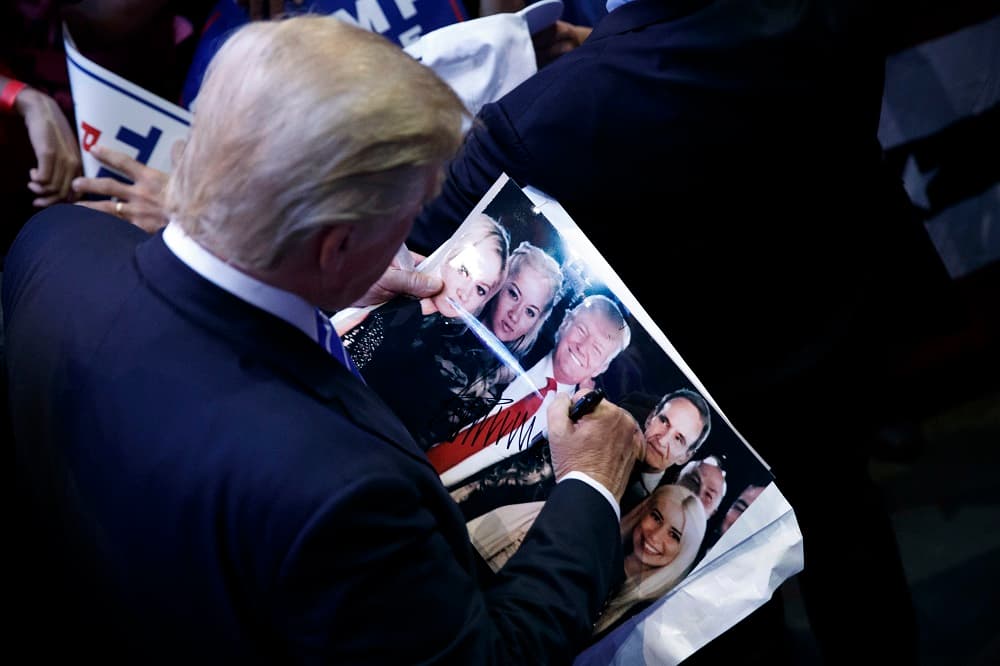 El candidato republicano Donald Trump firma autógrafos en un mitin de campaña en Sunrise (Florida).