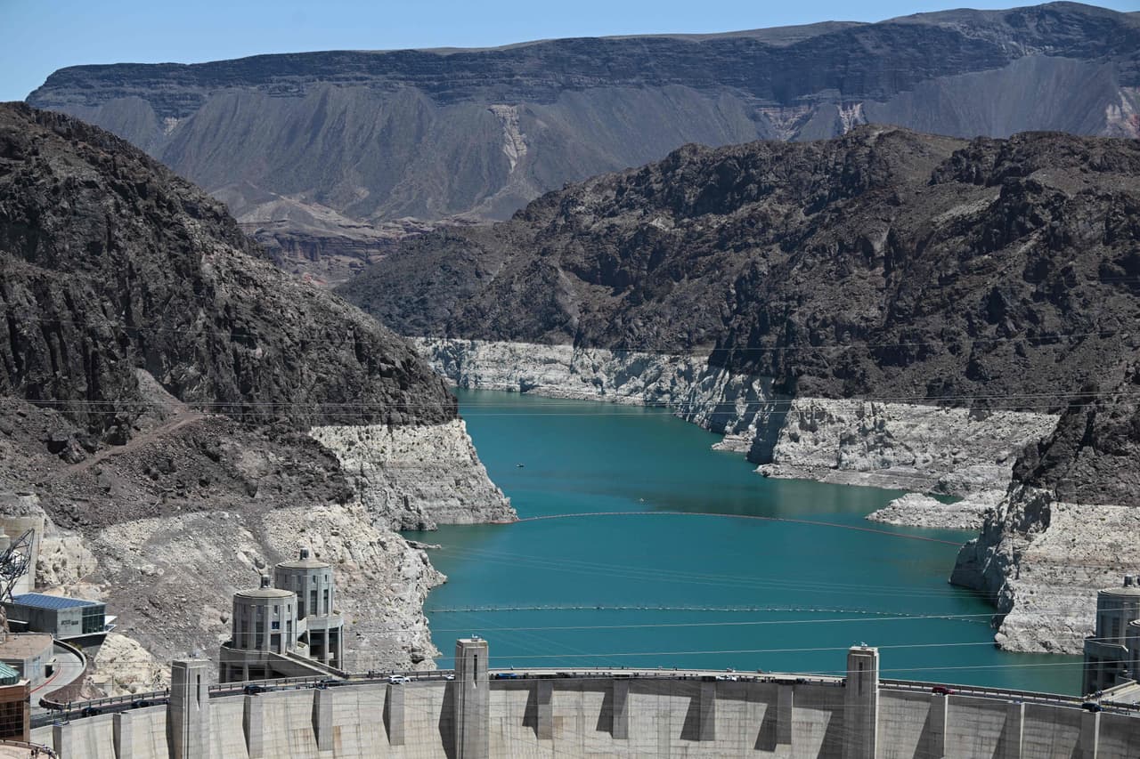 An aerial view shows the "bathtub ring", a white band of mineral deposits showing previous water levels, of Lake Mead on June 28, 2022 at the Hoover Dam on the Colorado River at the Nevada and Arizona state border. - Millions of gallons of Colorado River hurtle through the Hoover Dam every day, generating electricity for hundreds of thousands of homes. But the mega drought desiccating the western United States is sending reservoir levels plummeting towards deadpool -- the point at which the dam can no longer produce power. (Photo by Patrick T. FALLON / AFP) (Photo by PATRICK T. FALLON/AFP via Getty Images)