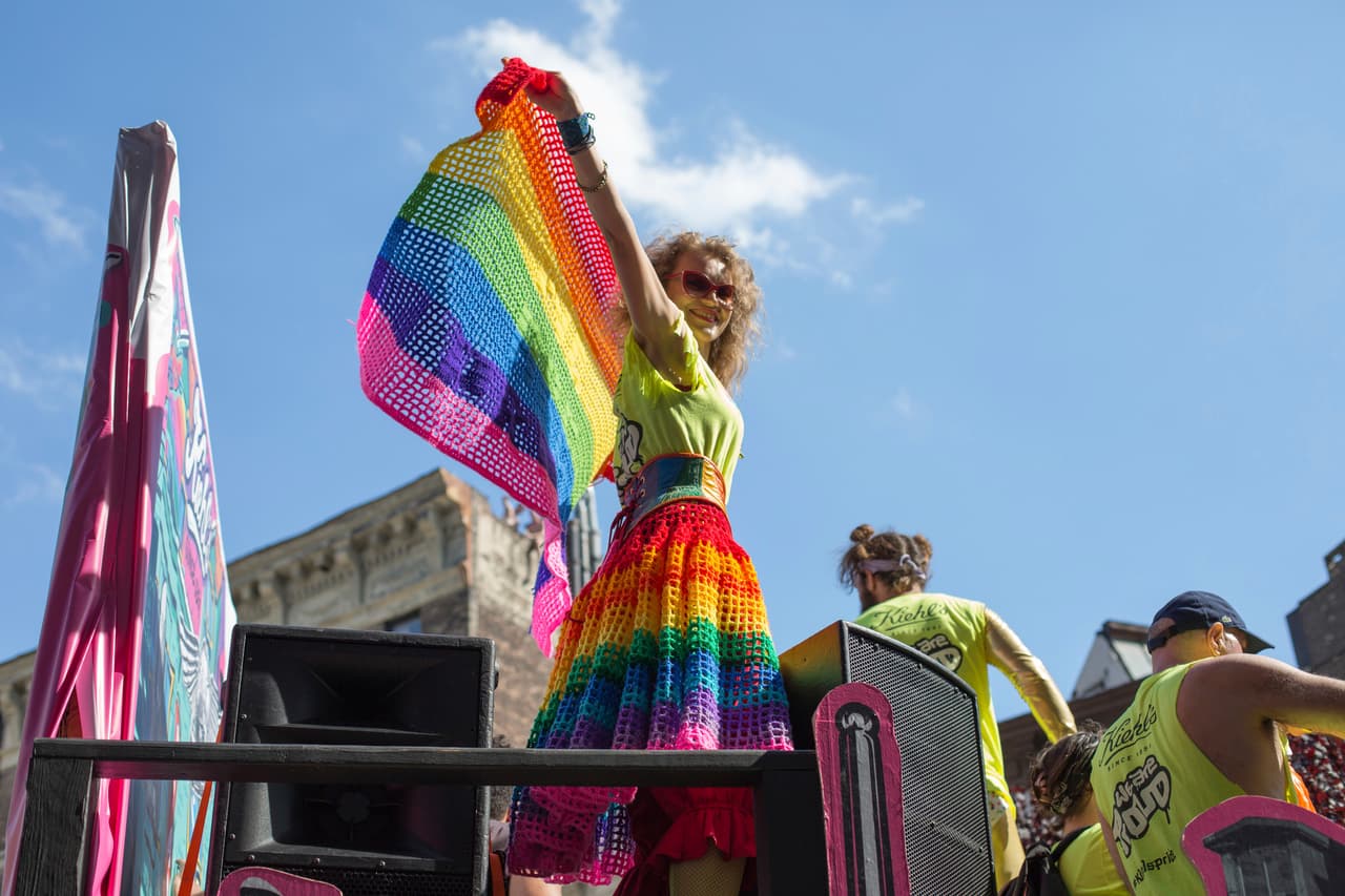 Un participante sostiene una bandera mientras avanza en un carro alegórico durante el desfile del orgullo de New York City.