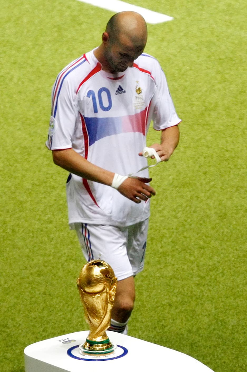 Tremenda imagen. Zinedine Zidane se marcha del campo por última vez con la cabeza abajo, mientras pasa junto a la Copa del Mundo.