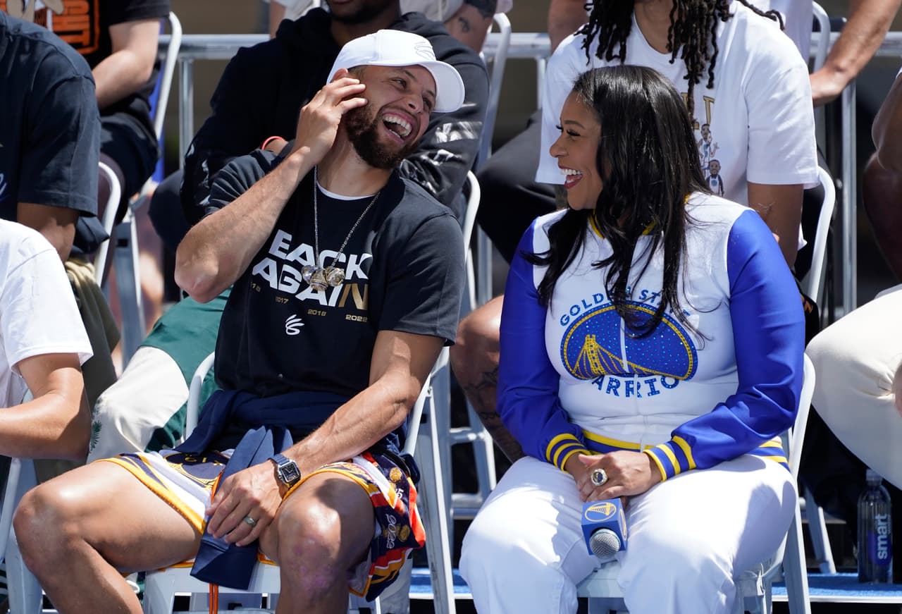 Stephen Curry, de los Golden State Warriors, se ríe con el alcalde de San Francisco, London Breed, en el escenario antes del inicio del desfile por el campeonato de la NBA en San Francisco, el lunes 20 de junio de 2022. (Foto AP/Eric Risberg)