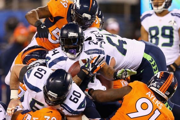 Los Seahawks, con un fútbol "total", el que había trabajado el entrenador del equipo durante toda la temporada regular, el veterano Pete Carroll, derrotaron por paliza de 43-8 a los Broncos, la mejor ofensiva de liga, con el mariscal de campo Peyton Manning a la cabeza. No habían pasado ni 12 segundos desde el comienzo del partido y los Seahawks ya hicieron historia con la anotación más rápida que se había dado jamás en un Super Bowl. Pero lo peor no fue el dejarse anotar dos puntos, sino la imagen de enfrentamiento entre Manning y el centro de origen mexicano Manny Ramírez, que no le dio bien al balón, y aunque el corredor Knowshon Moreno lo recuperó, lo hizo en la zona de protección. La mejor ofensiva de la NFL estaba paralizada, sin saber qué hacer, y ahí fue el comienzo y el final del partido disputado en el MetLife Stadium, de East Rutherford (Nueva Jersey), donde la temperatura fue de 43 grados. Malcom Smith recibió el premio de Jugador Más Valioso (MVP), el octavo defensor que lo consigue en un partido de Super Bowl y el tercer apoyador. Carroll, de 61 años, el tercer entrenador con más edad de la NFL que ganó un Super Bowl, se convirtió en el tercer entrenador que logra los dos títulos de campeón universitario de la NCAA con el equipo de USC y ahora los Seahawks en la NFL.