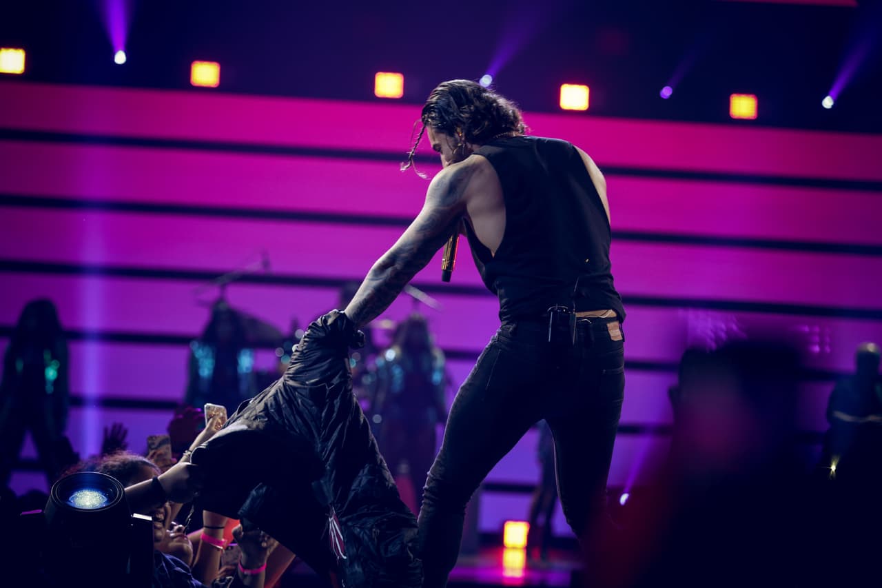 Al principio de 'El préstamo', Maluma debía desprenderse de su chamarra, pero no podía y tuvo que pedirle ayuda a una fan.