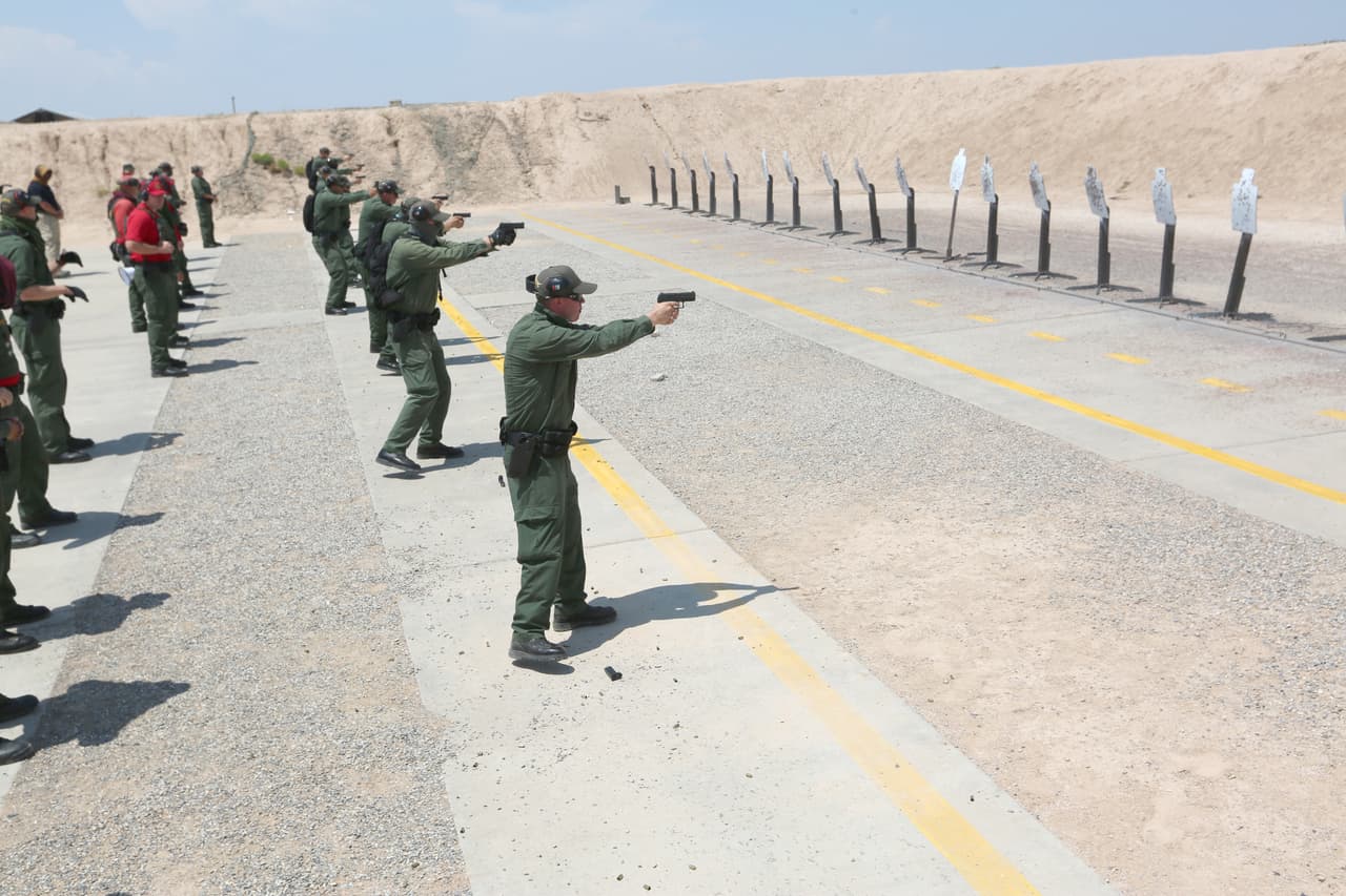 <b>Preparados para ir armados. </b>Bajo el sol de agosto, un grupo de estudiantes asiste a la clase de armas. Durante el resto del día, los aprendices cargan con pistolas de plástico e incluso rifles de imitación para acostumbrarse al peso y al hábito de trabajar con armas encima.