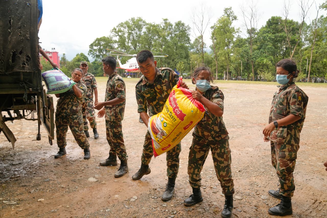 Soldados del ejército nepalí cargan suministros de ayuda para los supervivientes atrapados en zonas aisladas por las inundaciones repentinas en el distrito de Nuwakot, Nepal, el sábado 29 de agosto de 2026.
