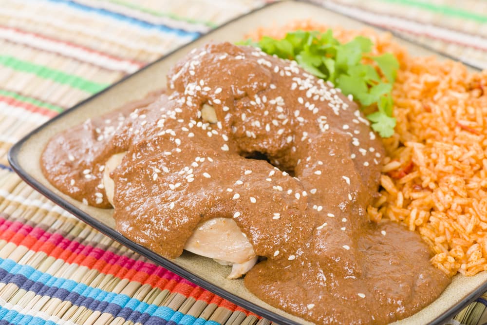 MOLE POBLANO. Esta receta mexicana cuenta con muchos años de antigüedad así como ingredientes. Entre ellos se encuentra el cacahuate que le da un toque difícil de describir, además de una cremosidad inigualable. Tendrás que probarlo forzosamente para saber a qué nos referimos.