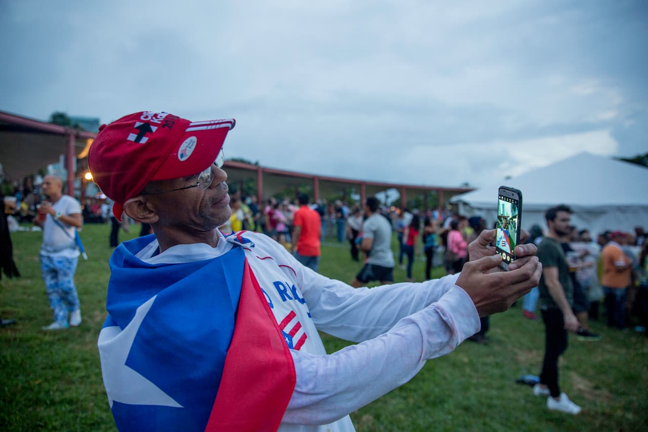 Felipe Pellecier viste la bandera de su natal Puerto Rico, mientras espera el comienzo del concierto.
<br>