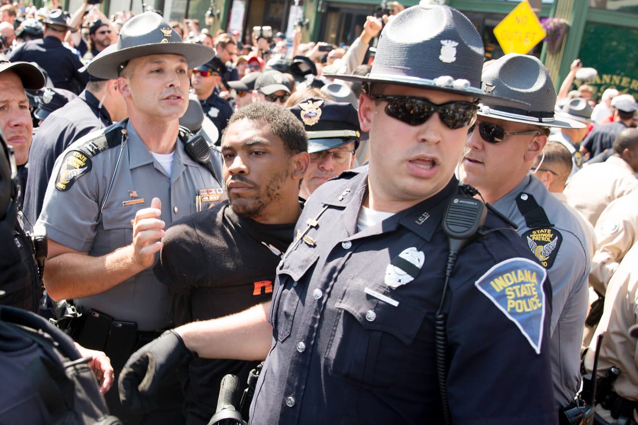 MIERCOLES 20 DE JULIO. 4:08 PM. Formados en un círculo, comenzaron a gritar consignas, sacaron una bandera y la rociaron de combustible. Al momento de encenderla la policía intervino, disolvió al grupo, hizo los arrestos y cerro el acceso peatonal a la convención temporalmente.