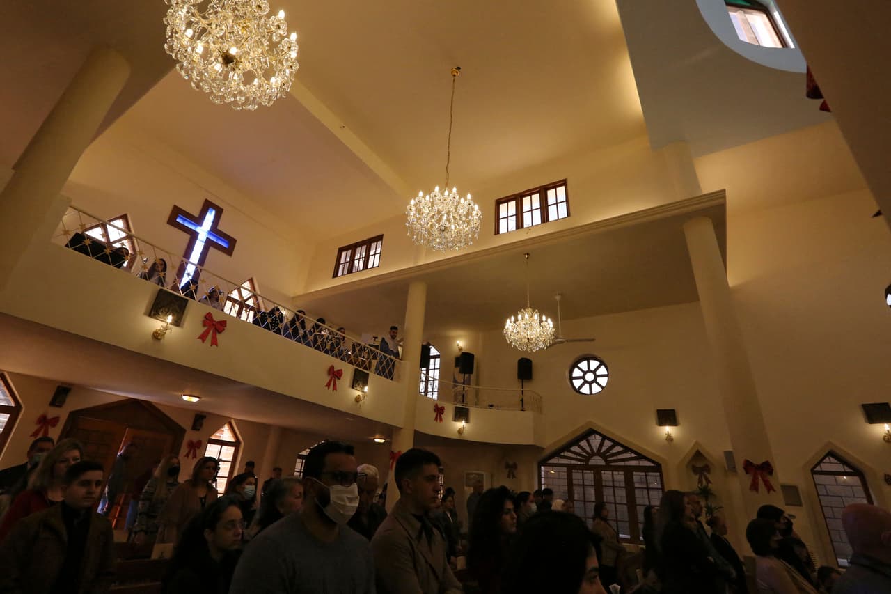 Esta foto muestra una imagen similar de cristianos reunidos en otra iglesia, esta vez en Bagdad, Irak.