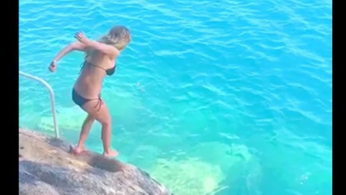 Estaba por lanzarse de un acantilado hacia el agua, como usualmente lo hace.