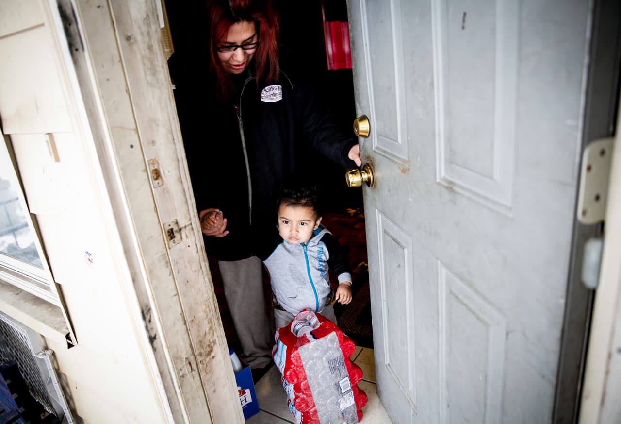 Sandra Mendez y su hijo, Alonzo Cabrera, 1, reciben agua del Red Cross en su hogar January 21, 2016 en Flint, Michigan. Mendez dijo que su hijo tiene una cita con el doctor para hacer una prueba de polmo.