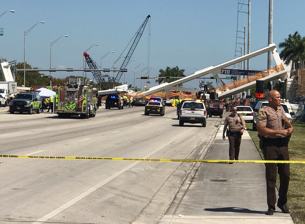 Police block a road near a newly installed pedestrian bridge, that collapsed, over a six-lane highway in Miami, Florida on March 15, 2018, crushing a number of cars below and reportedly leaving several people dead. The Miami Herald reported that an unknown number of people were trapped underneath the collapsed walkway, which connected Florida International University to a student housing area and was erected less than a week ago. / AFP PHOTO / AFP TV / Antoni BELCHI (Photo credit should read ANTONI BELCHI/AFP/Getty Images)