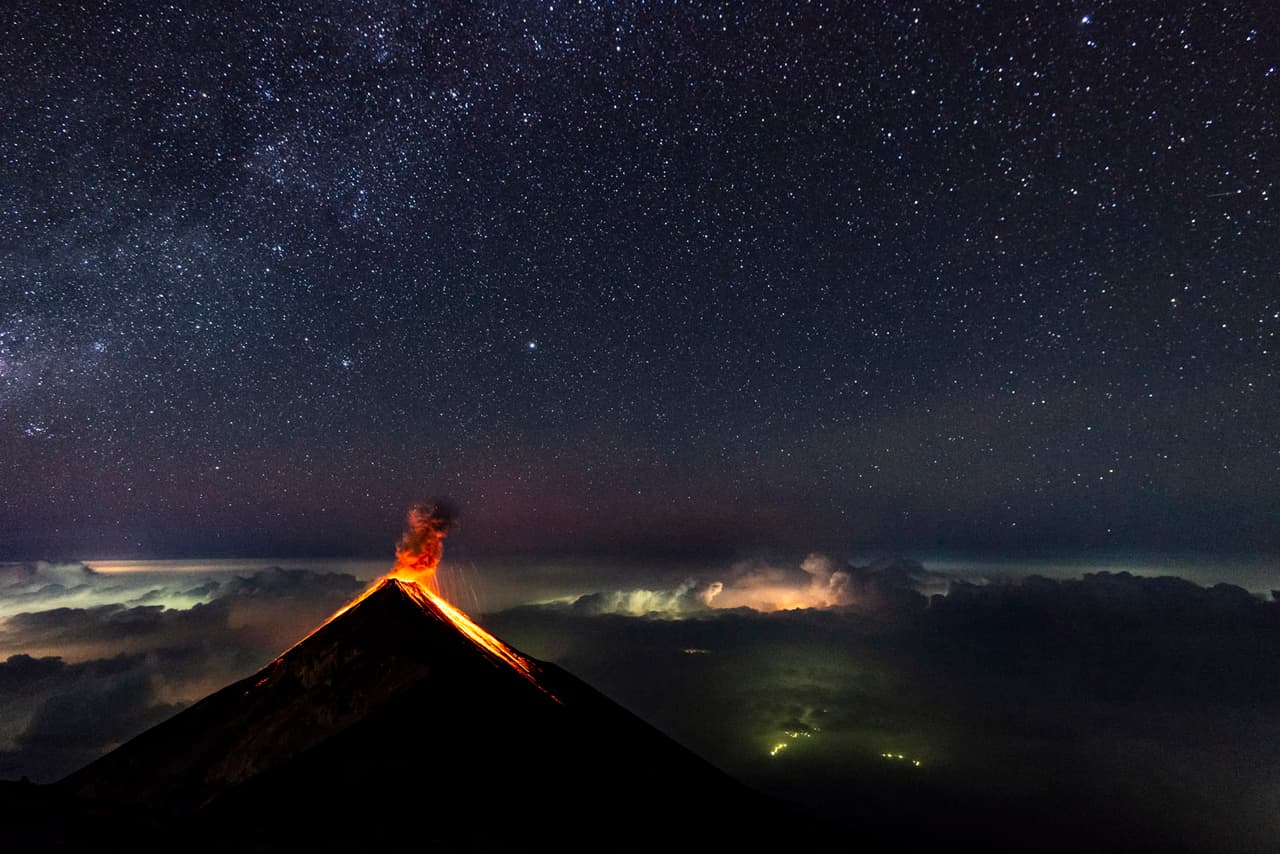 <b>Volcán de Fuego, cerca de Antigua, Guatemala.- </b>Esta foto del Volcán de Fuego fue tomada desde la cima del Volcán Acatenango, a 4,000 metros de altura. El cielo estaba despejado pero aún así, tomar fotos con tan poca luz supone una gran dificultad. Aquí, se ve al volcán arrojar lava bajo el cielo estrellado. / Crédito: Florent Mamelle, Francia. Ganador mejor imagen única en la Categoría Mundo Natural / 
<a href="www.tpoty.com" target="_blank">Tpoty</a>