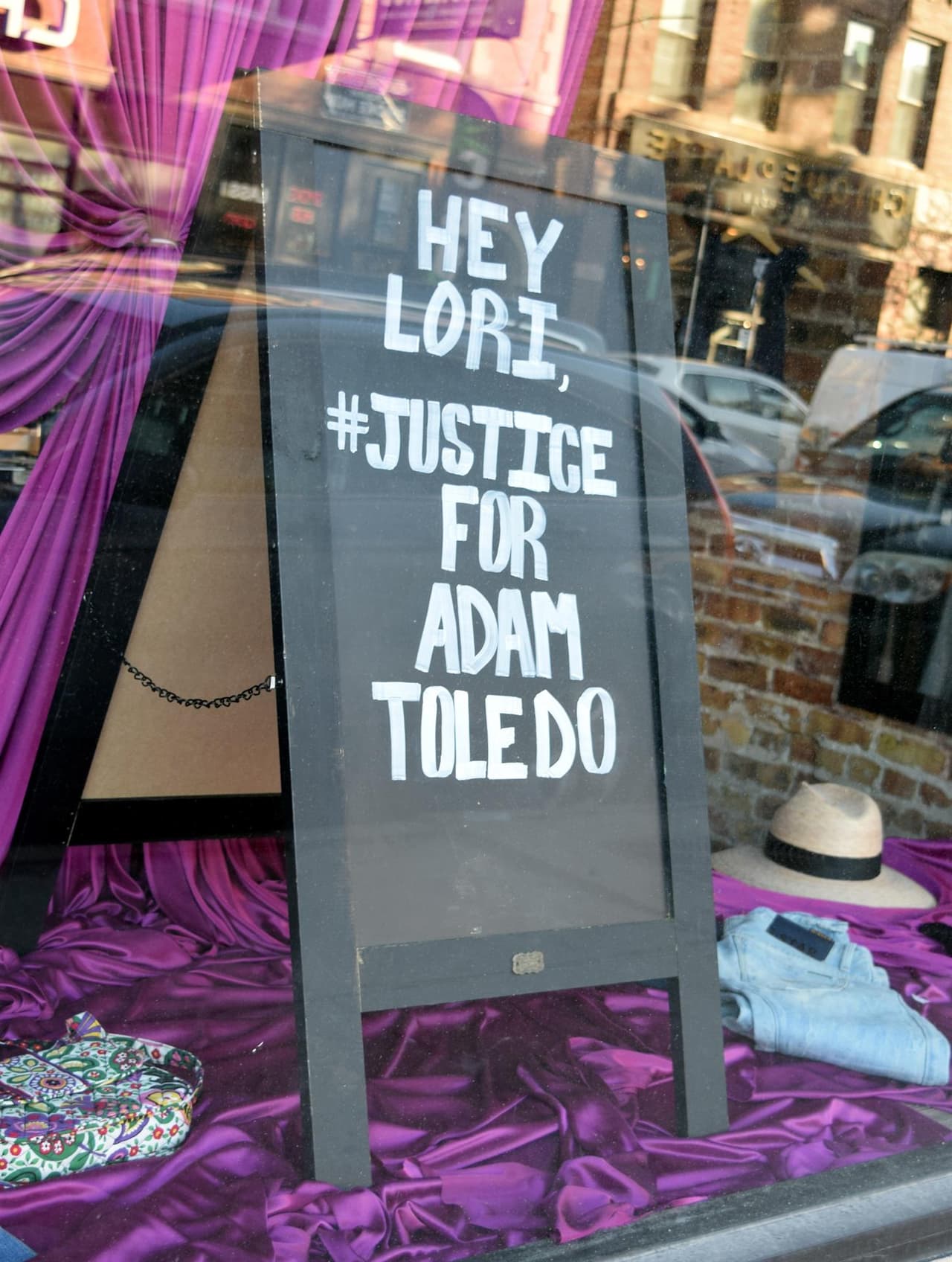 Fotografía de una pizarra que pide justicia para Adam Toledo, en la vitrina de un negocio en el barrio Logan Square, en Chicago. Los manifestantes protestaron también frente a casa de Lori Lightfoot, la alcaldesa de la ciudad, que vive en el mismo barrio. Lightfoot ha pedido que las personas se expresen pacíficamente.