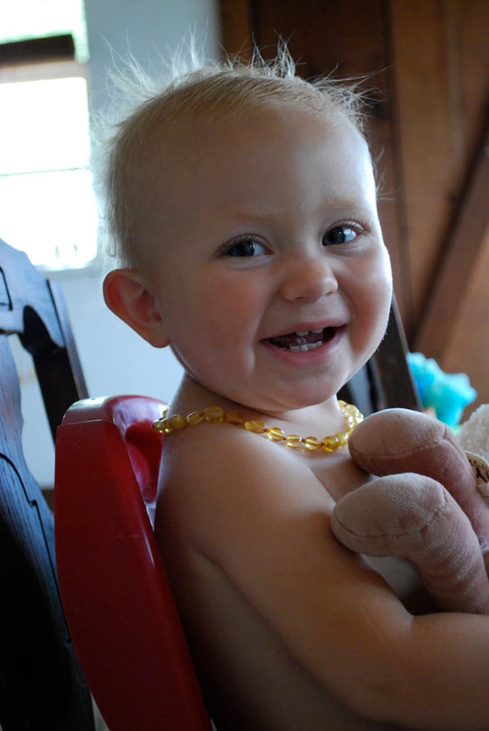 Imagen de archivo de un bebé usando un collar de ámbar para la dentición.