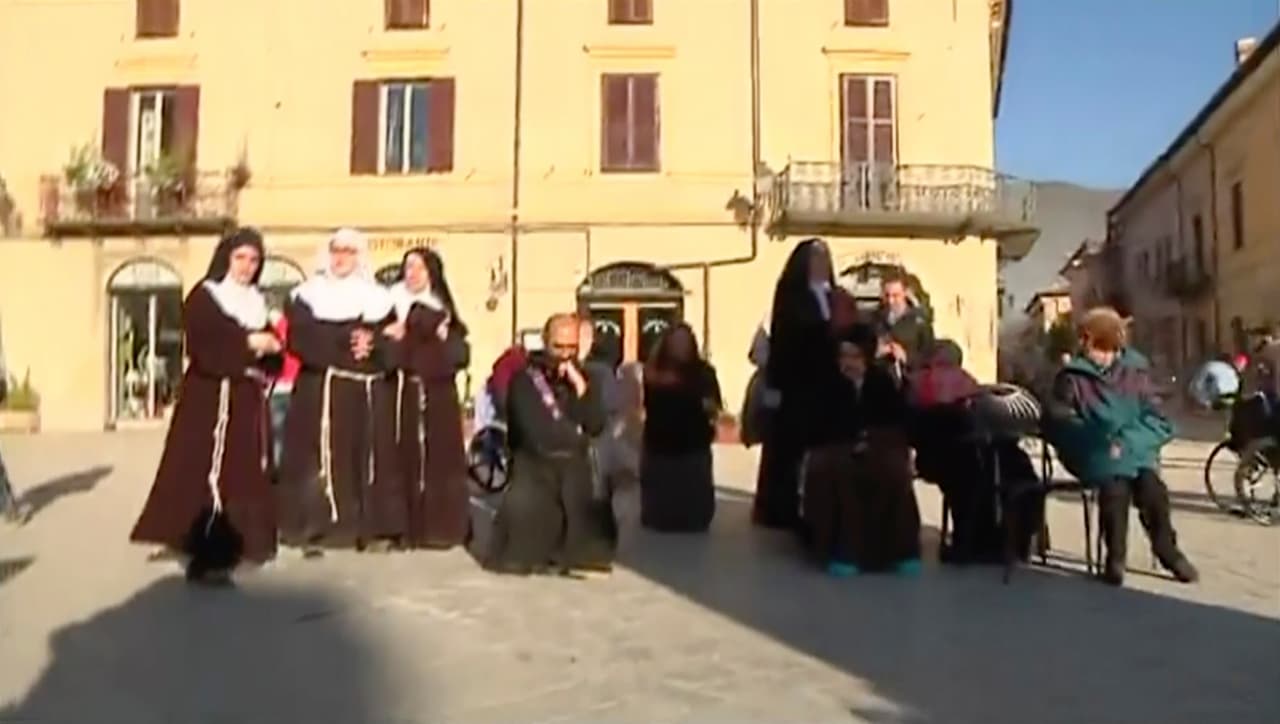 Imagen tomada de video muestra monjas que salieron apresuradamente de su iglesia, reunidas en una plaza con residentes que huyeron de sus casas, en Norcia, Italia, tras el sismo con magnitud preliminar de 6,6 ocurrido la mañana del domingo 30 de octubre de 2016, en el centro del país. (Sky Italia vía AP)