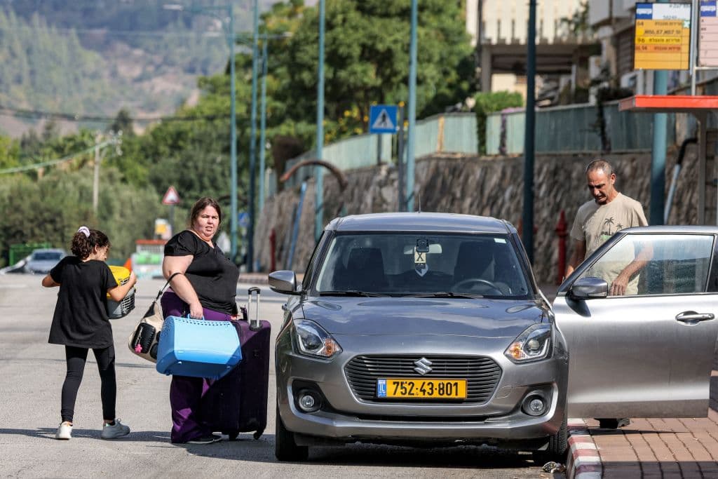 Una familia monta sus maletas en un auto mientras se preparan para evacuar la ciudad de Kiryat Shmona, cerca de la frontera con Líbano.