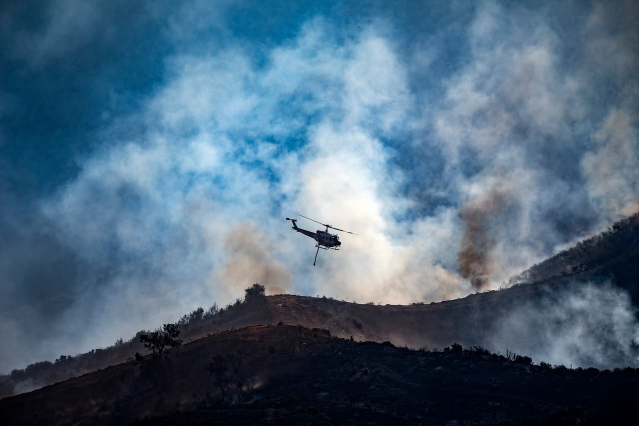 Un helicóptero de rescate sobrevuela Anaheim Hills, en uno de los incendios esparcidos por el estado.